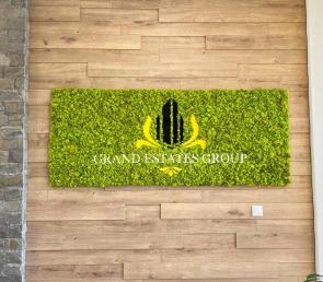 Зелена табела от мъх с логото на Grand Estate Group